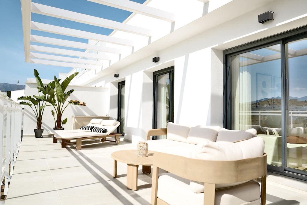 Ruim terras met loungebank, palmen en uitzicht op de bergen